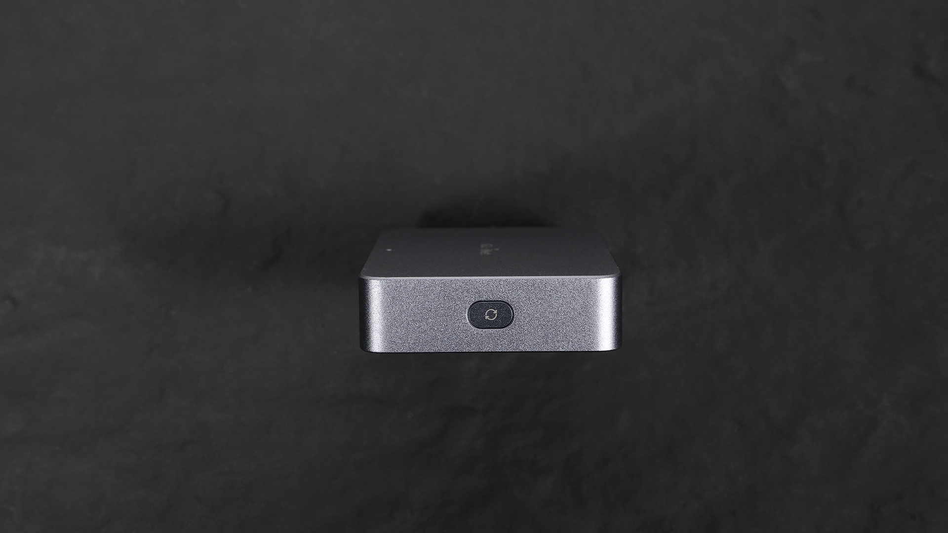 Close-up of the GL.iNet Comet (GL-RM1) KVM device showing the reset button on the side, used to restore factory settings.